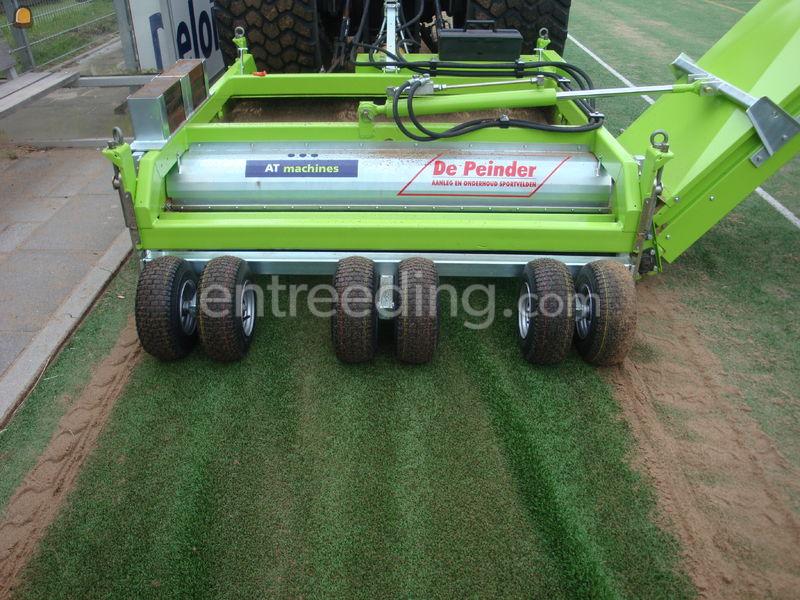 Tractor + rubber/infill uithaalmachine