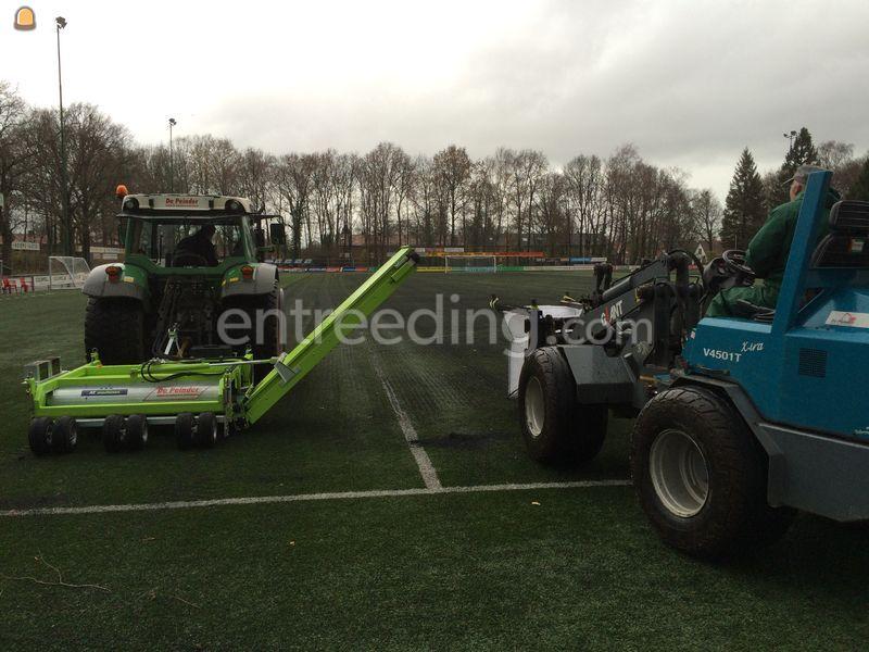 Tractor + rubber/infill uithaalmachine